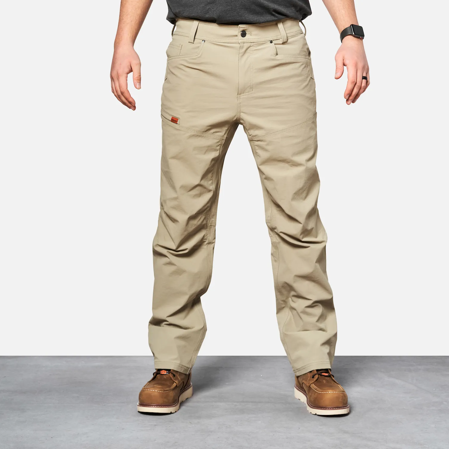 Tampilan depan celana kerja pria PERKASAJITU The Costello Tech Pant warna charcoal yang tahan air